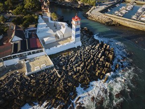 Aerial view of Santa Marta lighthouse and Cascais marina with moored yacht boats with Cascais