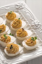 Boiled eggs stuffed with yolk with mayonnaise, on a white plate, selective focus, blurry, close-up,