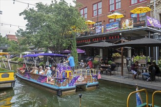 Oklahoma City, Oklahoma - Tourists ride a canal boat on the Bricktown Canal in Bricktown, a popular