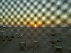 Berlin BER Airport, view through perforated window panes, taxiway at sunrise in November, Berlin,