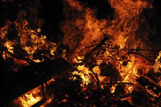 Intense flames and embers surround burning wood in the dark, campfire, Easter fire, Bavaria