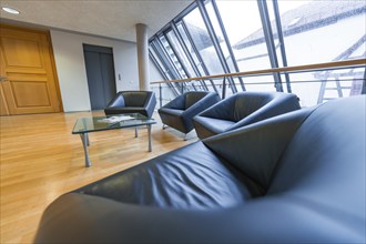 Cosy waiting area with black armchairs and large glass windows in a modern building, Nagold Town