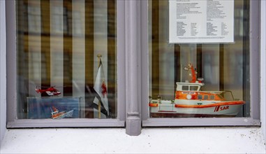 Window of a residential building in the city harbour of Stralsund, model of the rescue boat Hertha