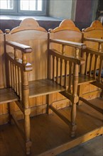 Traditional wooden church pews in a warm, stylish church interior, Suzana Orthodox Nunnery,