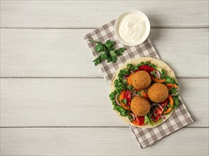 Tortillas, wrapped falafel balls, with fresh vegetables, vegetarian healthy food, on a wooden white