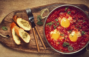 Shakshuka, breakfast, fried eggs in tomato sauce, with spices and herbs, homemade, no people