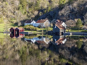 Fjord near Ana Sira at the norwegian southern coast, lonely houses at the of a rock formation,