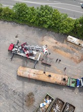 Detailed view of a construction site with a crane and several workers as well as various vehicles,