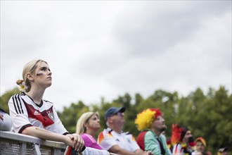 A woman watches the football match in the fan zone at the Brandenburg Tor during the quarter-final