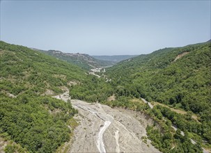 Only a trickle of water flows through the largely dry bed of the Torrente Nocito stream. Aerial