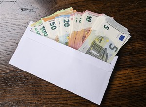 Envelope full of money, symbolic photo of pay packet, bribery