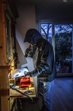 Symbolic image of a burglary, perpetrator has broken into a flat from the garden side and is