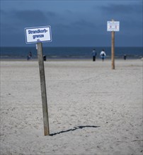 Beach chairs and signs on the sandy beach of the North Sea, Sankt Peter-Ording, Schleswig-Holstein,