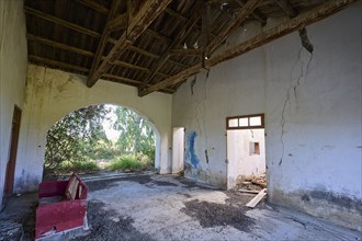 Abandoned building with cracks in the walls and a dilapidated interior. A passageway surrounded by