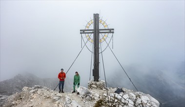 Mountaineer on the summit of the Großer Kinigat with summit cross, Carnic Main Ridge, Carnic High