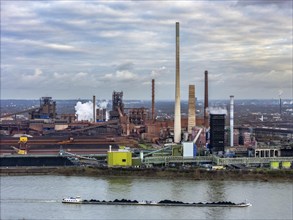 Industrial backdrop of the ThyssenKrupp Steel steelworks in Duisburg-Bruckhausen, cargo ship, coal