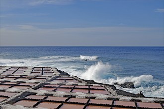 Coast with salt pans in the foreground, the sea with powerful waves in the background, salt pans,