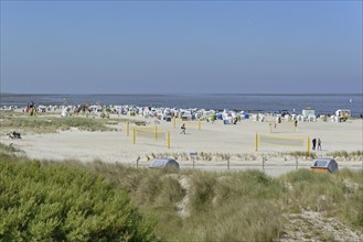 View over the dune landscape to the bathing beach with beach chairs, children's playground and