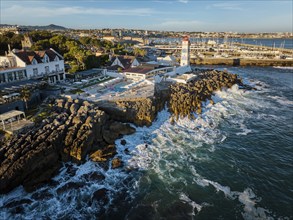 Aerial view of Santa Marta lighthouse and Cascais marina with moored yacht boats with Cascais