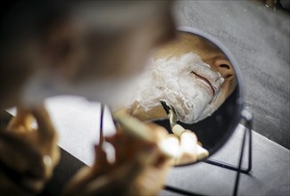 Symbolic photo on the subject of shaving. A man shaves his beard with a wet razor. Berlin, 13.08