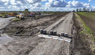 Construction vehicles are parked at an access road under construction to the High Tech Park at the