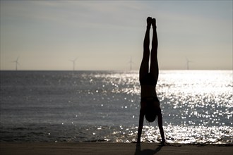 Girl doing a handstand by the sea, Silhouette, Søndervig Strand, North Sea, Denmark, Europe