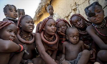 Group of Himba children and young woman look at pictures on a camera, near Opuwo, Kaokoveld,