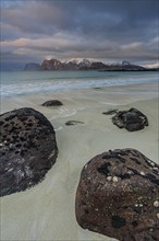 Rocks and beach in front of Bergen, sea, surf, spray, clouds, winter, Flakstadoya, Lofoten, Norway,