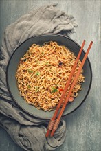 Instant noodles, in a bowl, on a gray table, top view, no people