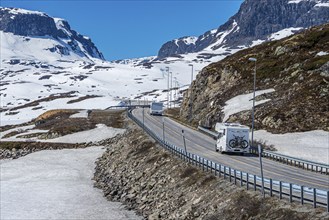 Camper vans driving through snowy high mountain landscape, Haukelivegen road, E134, Norway, Europe