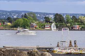 Pleasure boats passing the museum island Bygdøy, view to east side of Oslofjord, ferry stop for