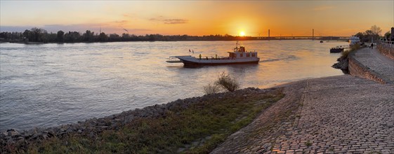 Sunset over river Rhine Lower Rhine, in the centre small passenger ferry two-wheel ferry Rees, on