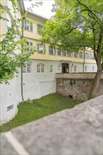 Tranquil view of a castle building with a wall and green nature in the foreground, Kirchheim Teck,