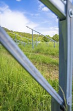 Metal structures for solar plants on a green meadow under a blue sky, construction of the Black