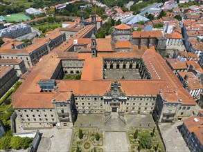 A large historic monastery building with a central courtyard and orange-coloured roofs, aerial