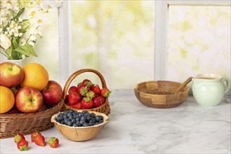 Healthy breakfast ingredients, fruit, strawberries and blueberries, ready for a meal in a wooden