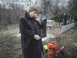 Ludmilla (68) mourns her grandson, who died at the front a month earlier, at the cemetery. The