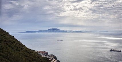 View of the calm sea with small ships and cloudy sky in the distance, Gibraltar, Europe