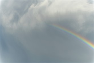 Rainbow appears in rain clouds in spring. Bas Rhin, Alsace, France, Europe