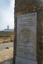 Stone plaque with information about Cabo da Roca, in the background a lighthouse, Cape Cabo da