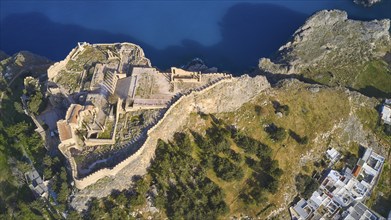 Drone shot, Acropolis of Lindos, late afternoon light, aerial view of a ruined fortress on a cliff