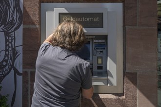 Man withdrawing money from an ATM, Nuremberg, Middle Franconia, Nuremberg, Germany, Europe