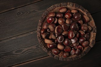 Fresh chestnuts, in a wooden bowl, top view, no people