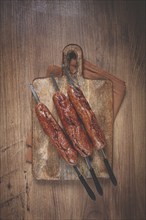 Fried sausages, in English with bacon, for grilling, on a cutting board, top view, no people