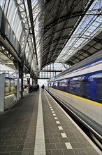 Departing train at the central station of the capital, Amsterdam Centraal, Amsterdam, Province of