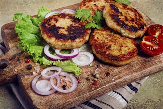 Fried chicken cutlets, minced chicken, with vegetables, on a cutting board, with vegetable salad,