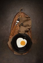 Fried egg in a cast-iron pan, breakfast, fried eggs in the shape of a heart, top view, no people,