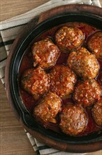 Minced meat meatballs, in tomato sauce, in a cast-iron pan, homemade, no people