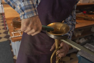 Metal instrument maker dents the bell of a trumpet, Magdeburg, Saxony-Anhalt, Germany, Europe