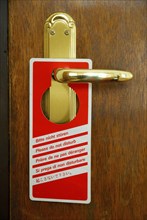 Sign on door handle of hotel room 'Do not disturb', Please do not disturb, door handle